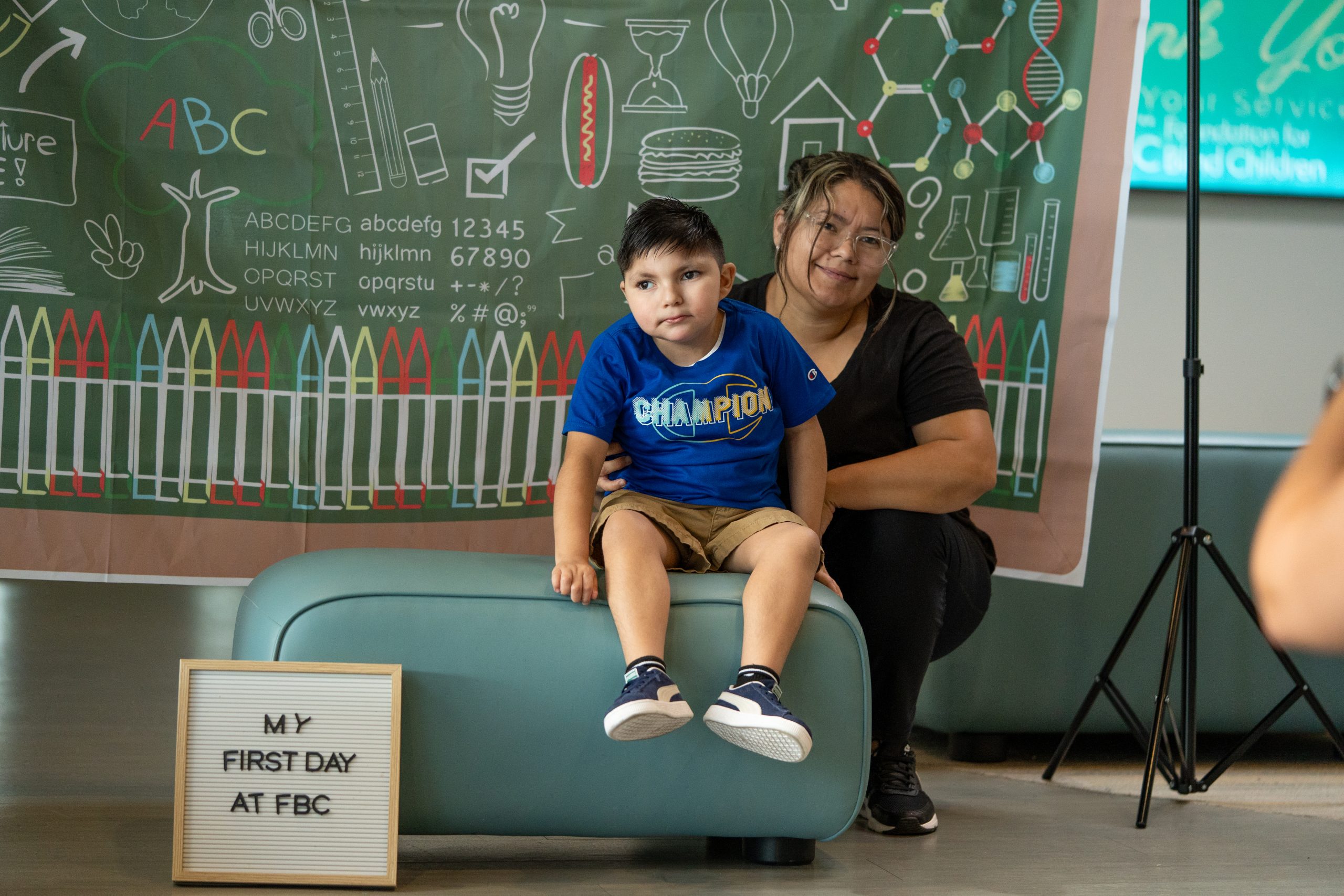A young boy and his mother smile for the camera at FBCs main building