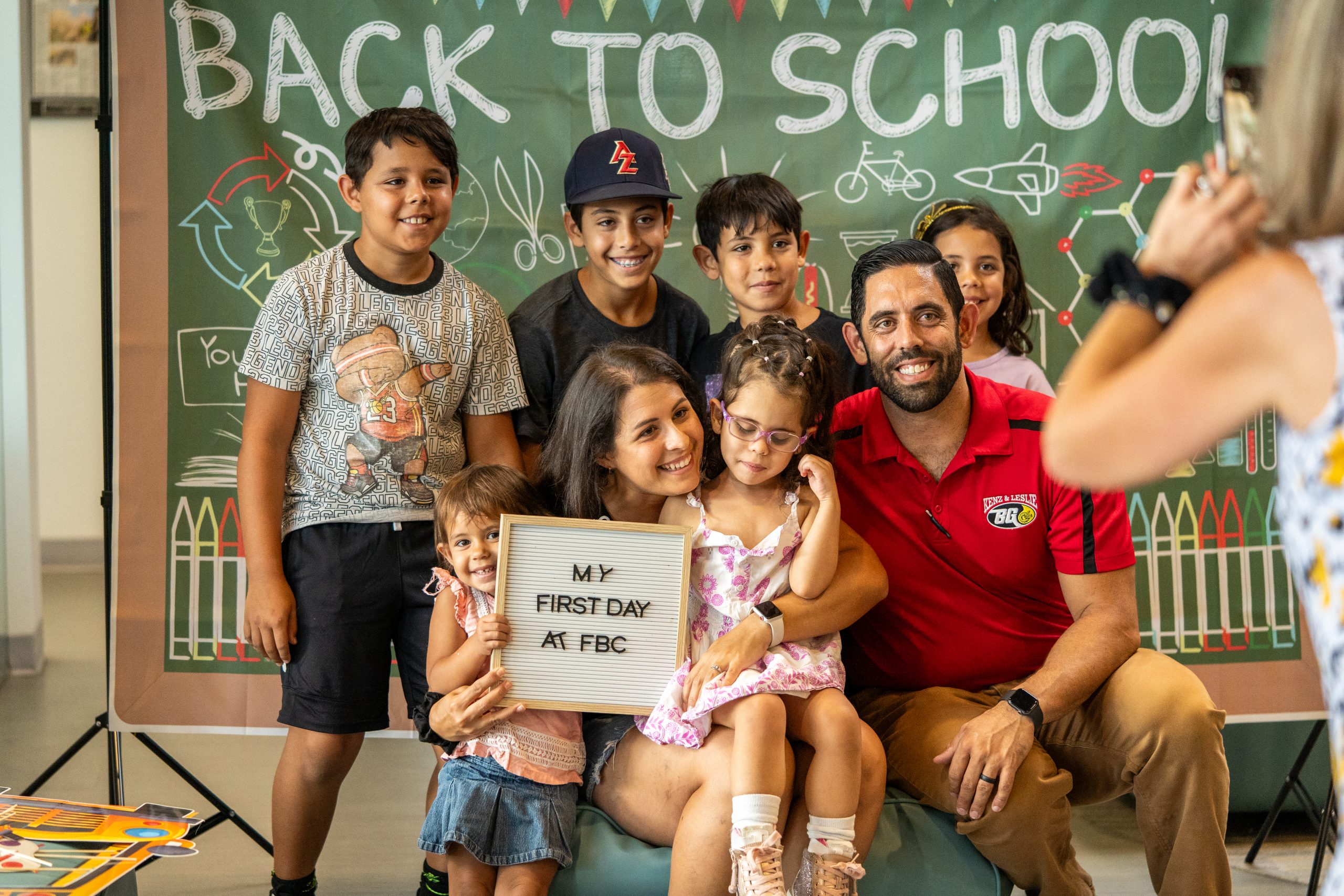 A family of eight smile together on the first day of school.
